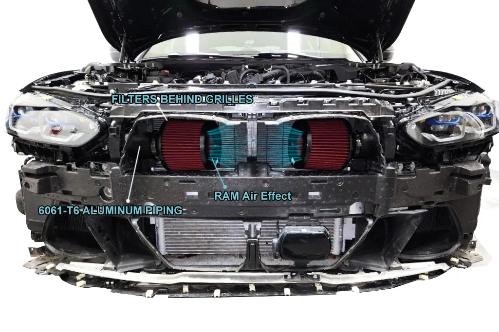 Alt text showing BMW S58 front mount aluminum intake with visible TIG fish-scale welds and CNC machined bungs, filters positioned behind kidney grilles.